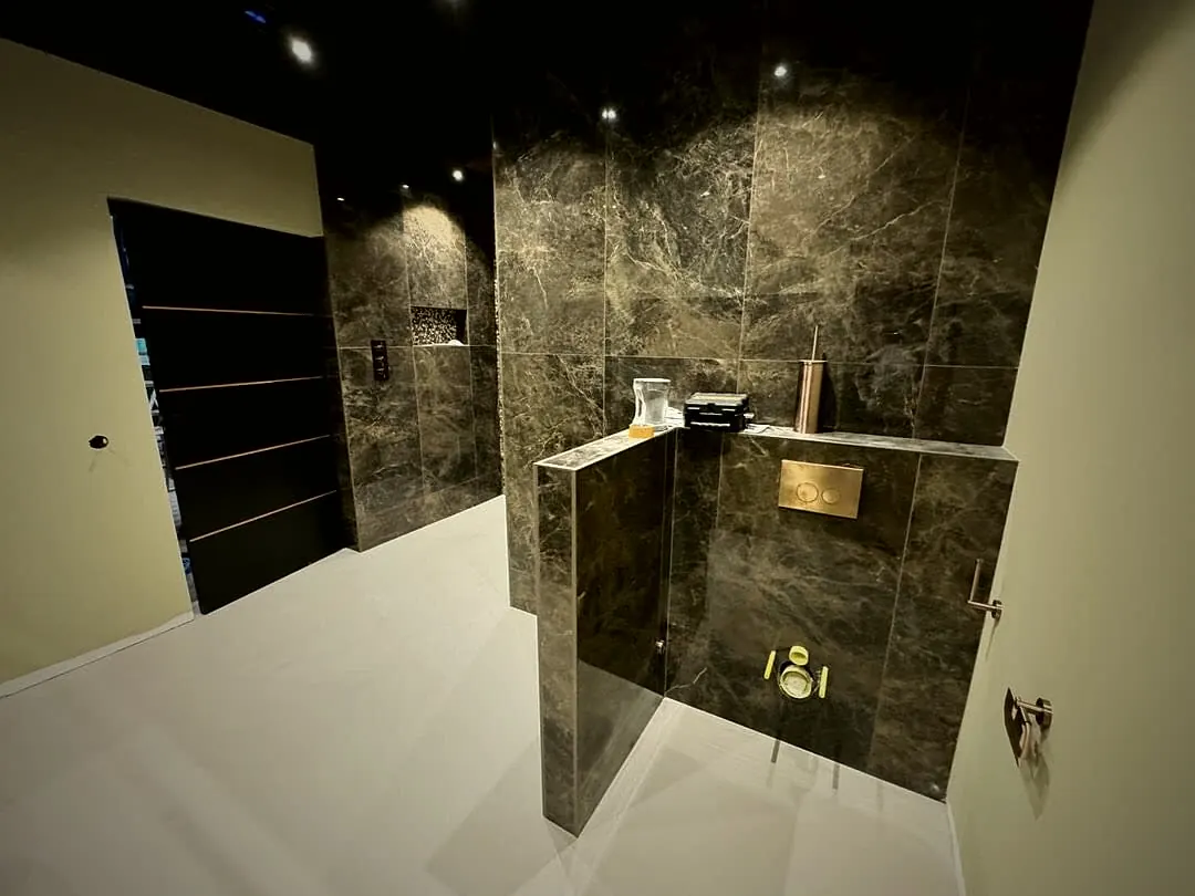 Badkamer met marmerlook wandafwerking en een lichte naadloze vloer