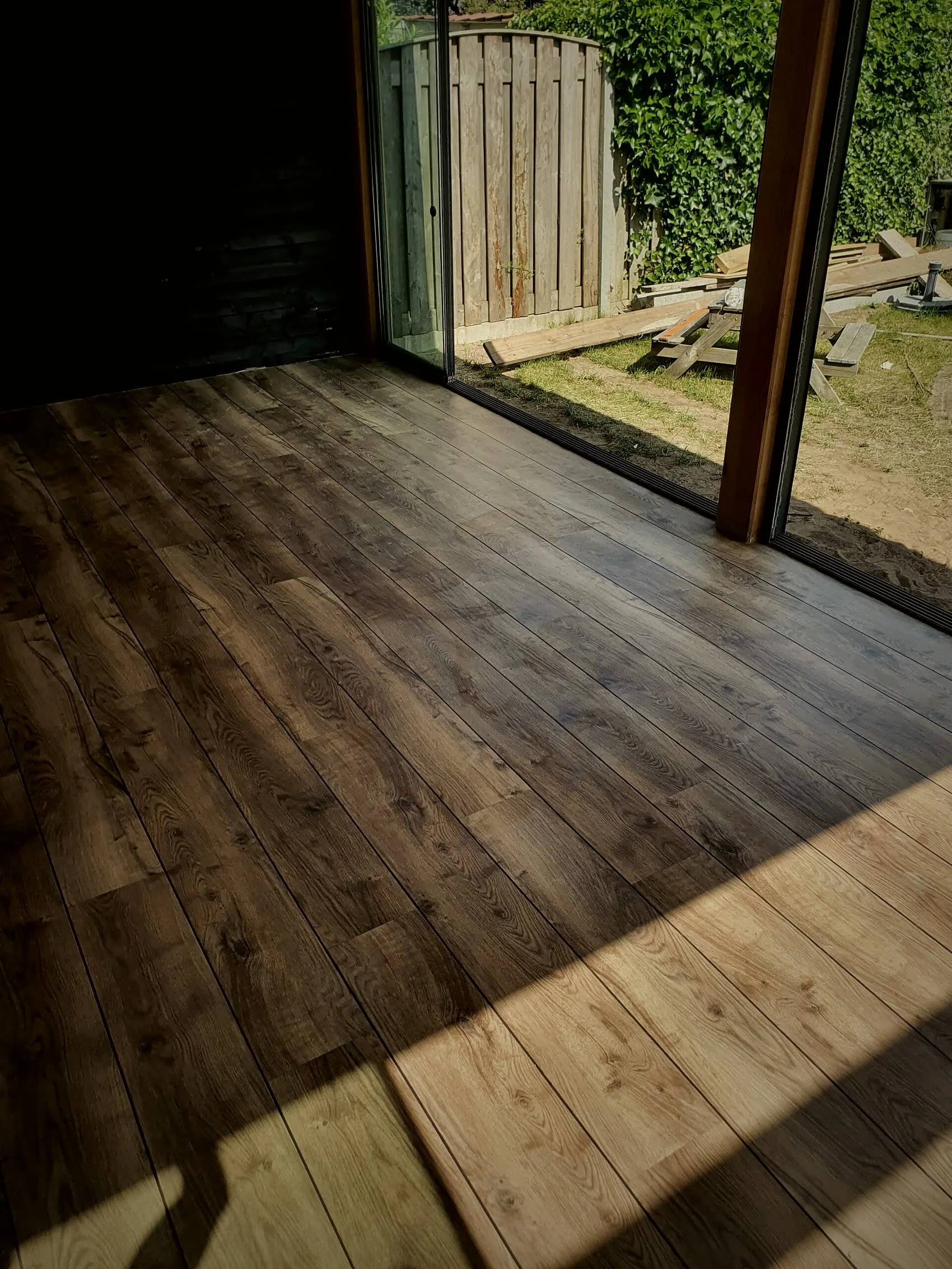 Woonkamer met houtlook PVC vloer tot aan de tuindeuren